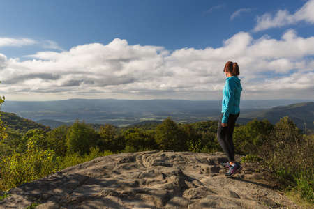Woman inspirationally looking down from the Skyline Drive in the Shenandoah National Park, woman has this inspirational view across the valleys and mountains belowの写真素材