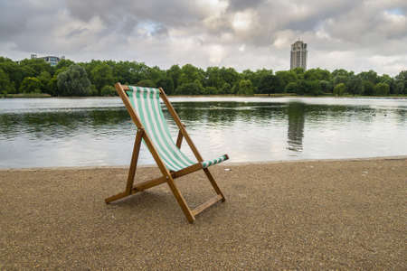 A lone deck chair early in the morning by the Serpentine, Hyde Park, London