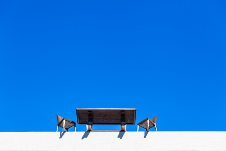 Desk table chairs on the building edge for a meeting fallout in the blue skyの写真素材
