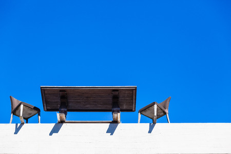 Desk table chairs on the building edge for a meeting fallout in the blue skyの写真素材
