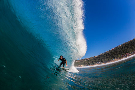 Surfer riding inside pitching hollow wave, water perspective 