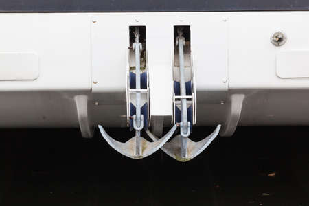 Two anchors on chains together suspended above water from sailing boat design の写真素材