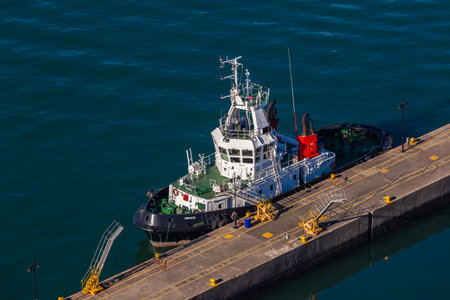Harbor tug vessel moored alongside pier jetty High elevation air photo of the diesel powered vessel...