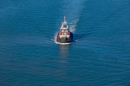 Harbor tug vessel high elevation air photo of the diesel powered vessel on the sea waters の写真素材
