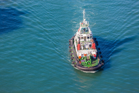 Harbor tug vessel high elevation air photo of the diesel powered vessel on the bay waters の写真素材