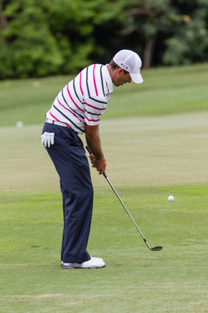 Professional Charl Schwartzel chips and strikes his ball at the European pga Volvo Golf Champions tournament at Durban Country club South Africaのeditorial素材