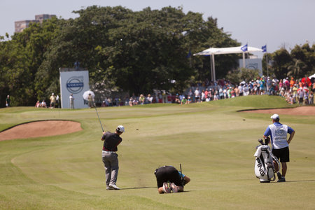 Professional Golfer Louis Oosthuizen and tv camera swings to strike ball at European PGA Tournament Volvo Golf Champions Tournament play action at Durban Country Club  January 2014 South Africaのeditorial素材