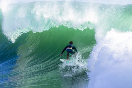 Surfing large cyclone summer waves surfer at Durban s north beach surf city の写真素材
