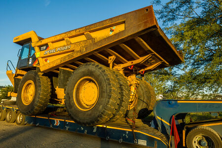 Large abnormal open cast mining heavy earth bucket truck vehicles on transport trailers to mining...