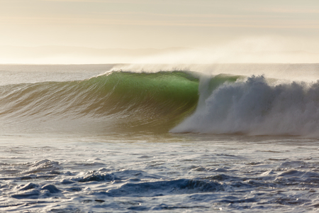 Morning backlight good size ocean wave wall of water upright crashing on shallow reefsの写真素材