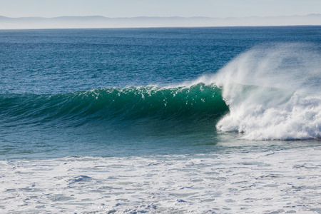 Overlooking good size ocean wave wall of water upright crashing on shallow reefsの写真素材