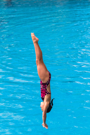Girl in mid flight dive at national aquatic diving competitionのeditorial素材