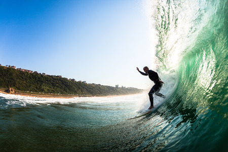 Surfer catching dropping riding surfing hollow crashing wave, a water swimming view of the action 