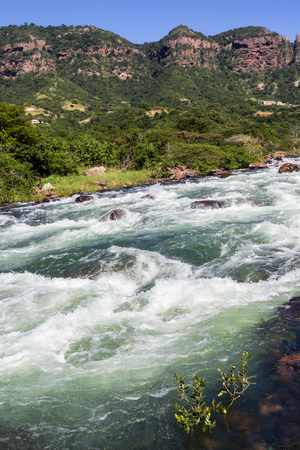 Rushing river water rapids over dangerous rocks in rural  valleyの写真素材