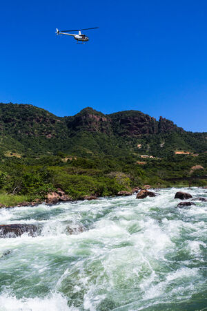 River Water Rapids with helicopter above in blue skyの写真素材