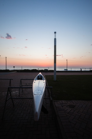 Surf-Ski water craft on trestles at dawn sun rising over ocean waters and sky の写真素材