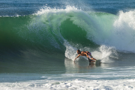 Surfing Surfer doing solid bottom turn to ride good size waveのeditorial素材