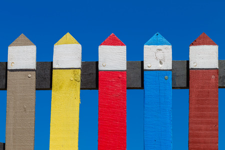 Wood fence painted pastel colors vibrance against blue skyの写真素材
