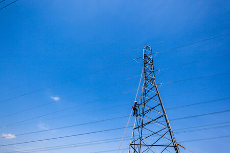 Steel Electrical power pylons with maintenance teams up high on cable connectors の写真素材