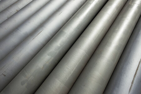 Steel metal water liquid pipes placed together on construction siteの写真素材