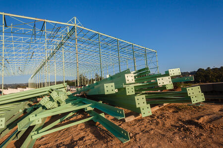Steel frame warehouse building structure being put together piece by pieceの写真素材
