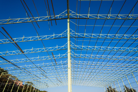 Steel frame warehouse building structure being put together piece by pieceの写真素材