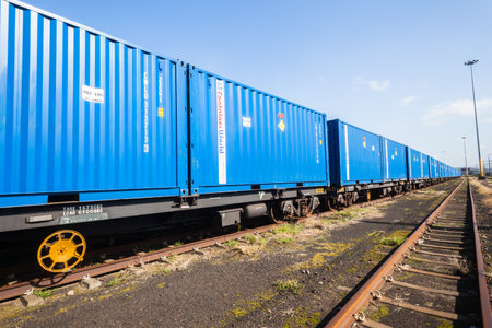 Train with blue containers in shipping yard to exportのeditorial素材