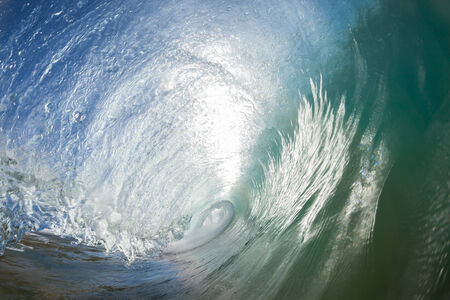 Ocean wave inside hollow crashing on shallow reefs nearby beach coastlineの写真素材
