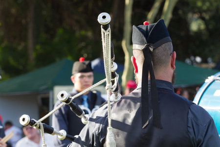 Scottish Bands men and women play musical instruments in traditional colors at the Scottish Highland Gathering のeditorial素材