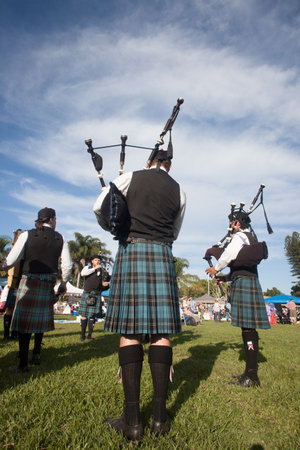 Scottish Bands men and women play musical instruments in traditional colors at the Scottish Highland Gathering のeditorial素材