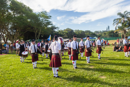 Scottish Bands men and women play musical instruments in traditional colors at the Scottish Highland Gathering のeditorial素材