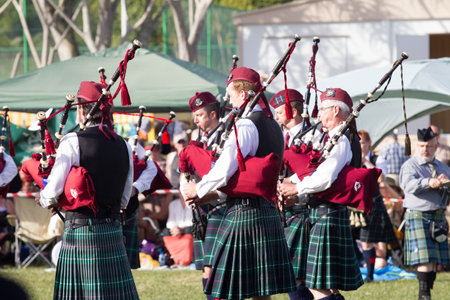 Scottish Bands men and women play musical instruments in traditional colors at the Scottish Highland Gathering のeditorial素材