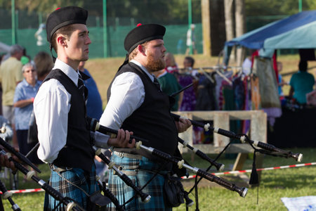 Scottish Bands men and women play musical instruments in traditional colors at the Scottish Highland Gathering のeditorial素材