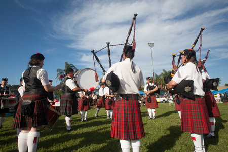 Scottish Bands men and women play musical instruments in traditional colors at the Scottish Highland Gathering のeditorial素材
