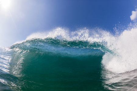 Blue ocean wave wall of sea water upright round crashing breaking onto reef beach shallowsの写真素材
