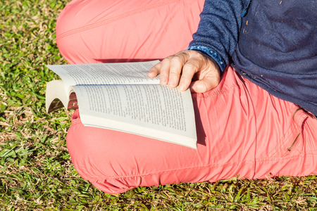 Woman Hands reading glasses book outdoors close-up detailの写真素材