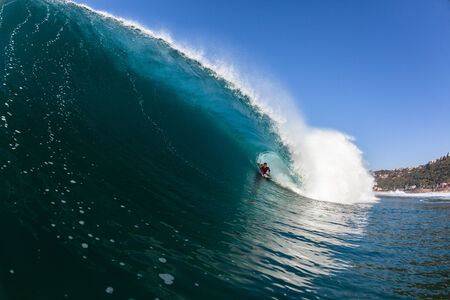 Surfing rider on tube rides inside large blue hollow ocean wave, a swimming action photo of  hollow scenic power of natureの写真素材