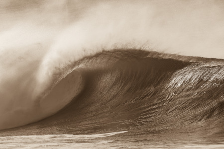 Ocean wave crashing curling lip in sepia vintage contrastの写真素材
