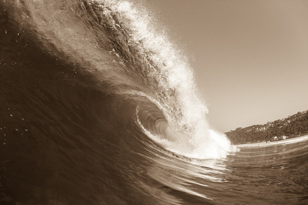 Ocean wave crashing curling lip in sepia vintage contrastの写真素材