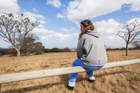 Young girl teenager sitting relaxing park wilderness reserveの写真素材