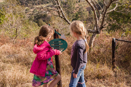 Young girl caring assists friend back to camping site in rural countrysideの写真素材