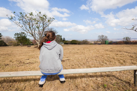 Young girl teenager sitting pondering park wilderness reserveの写真素材