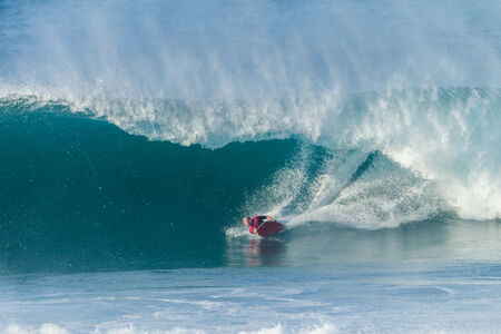 Surfing body boarding large hollow wavesの写真素材