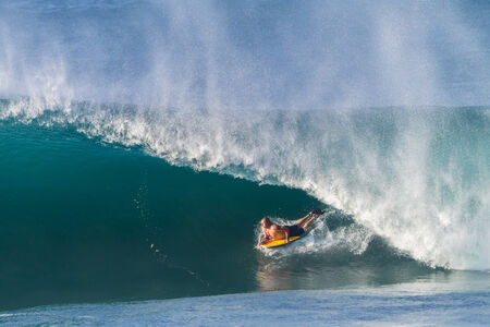Surfing body boarding large hollow wavesの写真素材