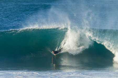 Surfing body boarding large hollow wavesの写真素材