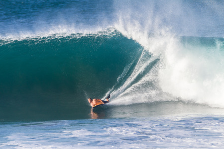 Surfing body boarding large hollow wavesの写真素材