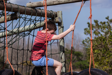 Young boy climbing playground ropes tyre s swing apparatusの写真素材