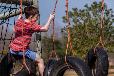 Young boy climbing playground ropes tyre s swing apparatusの写真素材