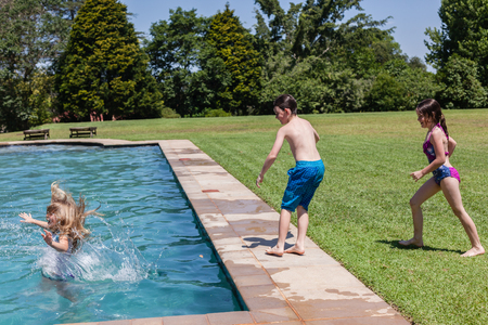 Boy girls playing swimming pool home summer