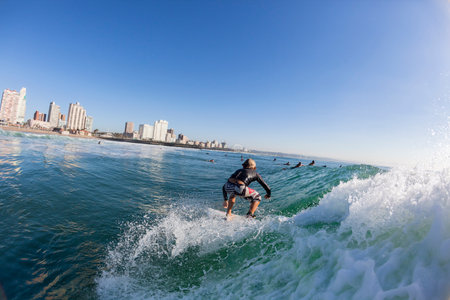 Surfer junior boy surfing water action D rban beachfrontのeditorial素材